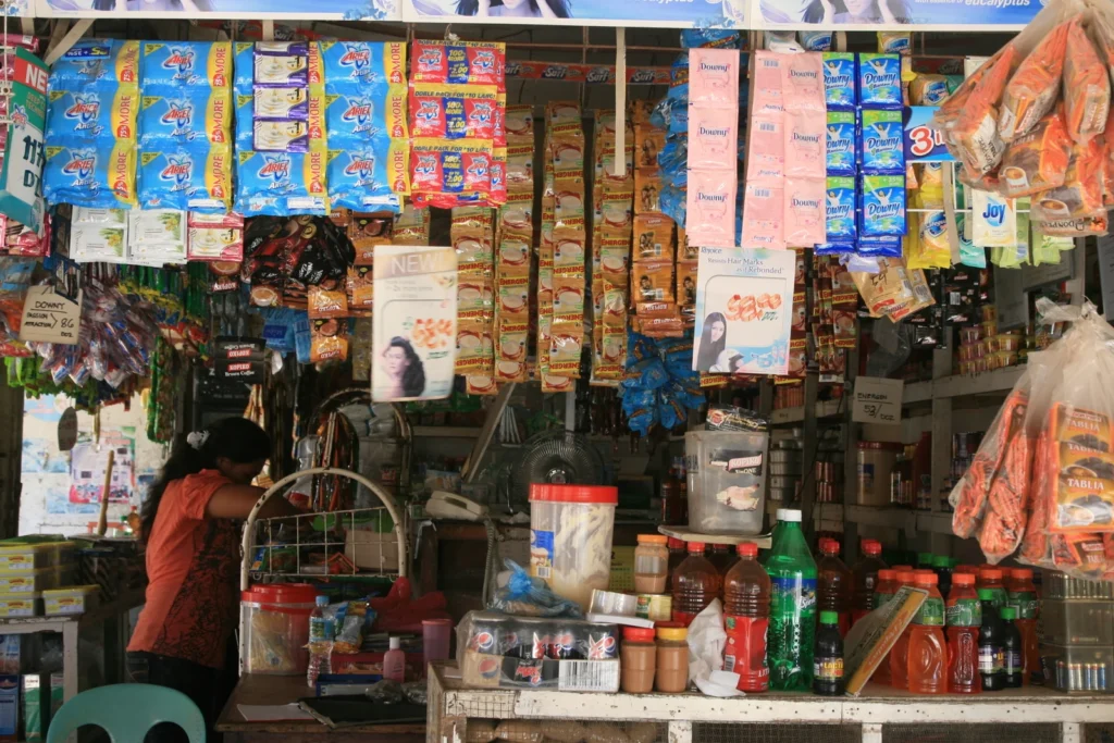 Sari-sari store in the Philippines with sachets of snacks, instant noodles and detergent hanging above the counter